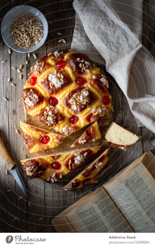 Coca de San Juan auf rustikalem Tisch Gebäck traditionell frisch coca de san juan Buch Rezept Messer Handtuch Samen Lebensmittel selbstgemacht Bäckerei Dessert