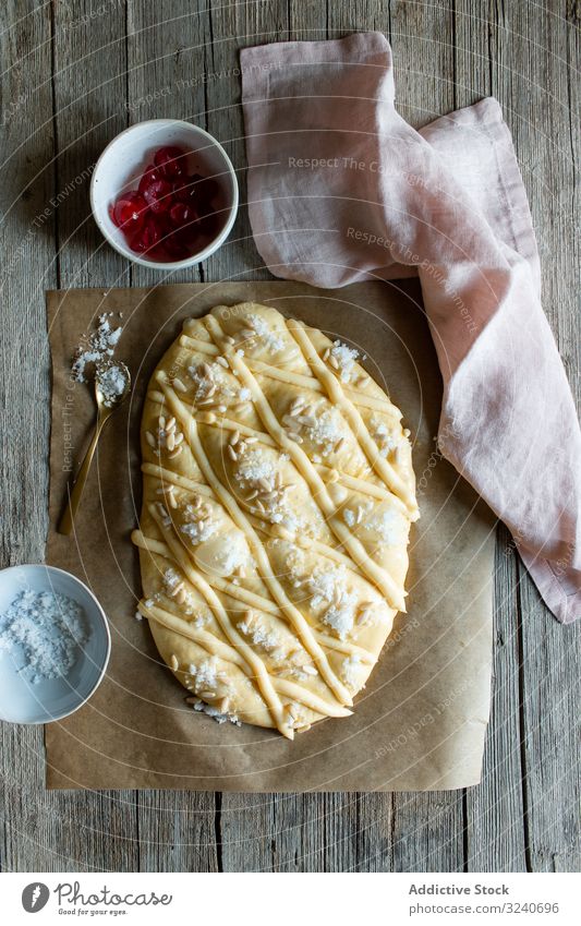 Coca de San Juan auf rustikalem Tisch Gebäck traditionell frisch coca de san juan Buch Rezept Messer Handtuch Samen Lebensmittel selbstgemacht Bäckerei Dessert