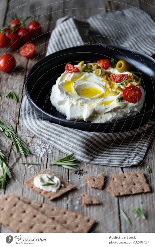 Cracker und Kräuter in Tellernähe mit Labneh Joghurt frisch labneh Käse Rosmarin Tomate oliv Sahne Griechen Serviette traditionell Küche Mahlzeit Portion Speise