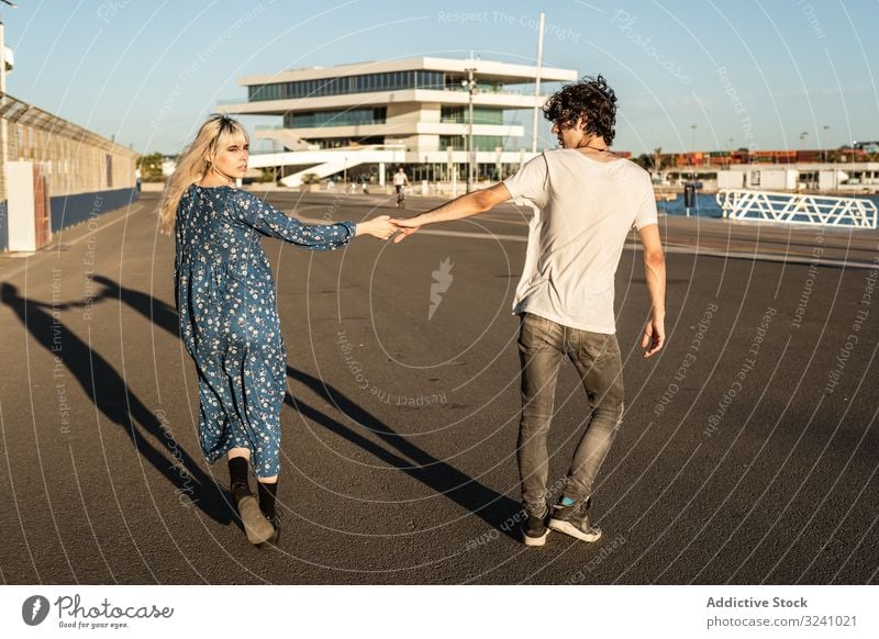 Paar hält sich beim Spaziergang entlang der Straße im Hafen an den Händen Weg Partnerschaft wählen Wahl Konzept Liebe Freund Freundin Neugier trendy Interesse