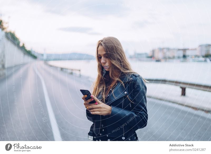 Langhaarige stylische Frau surft auf Smartphone Telefonanruf Großstadt ernst Nachrichten Straße klug Sprechen Empfang Budapest benutzend fokussiert Gespräch