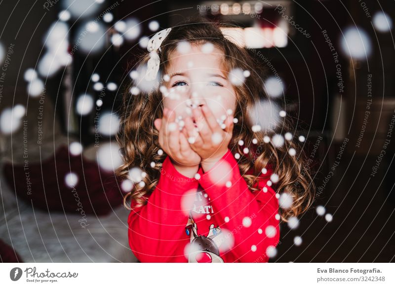 junges Mädchen, das zu Hause künstliche Schneeflocken bläst. Weihnachten Freude schön Spielen Winter Weihnachten & Advent Kind feminin Kleinkind 1 Mensch