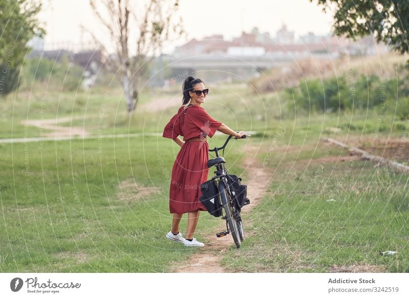 Frau mit Fahrrad im Park unterwegs Spaziergang Weg Lächeln lässig Großstadt Sommer Aktivität Fahrzeug Verkehr schieben Lifestyle ruhen sich[Akk] entspannen