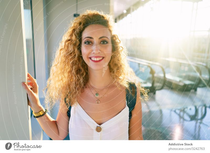 Angenehme Frau in sonniger Halle des Flughafens schaut weg Rolltreppe träumen reisen modern Vorfreude Rucksack aufgeregt Tourismus Reisender Urlaub Vergnügen