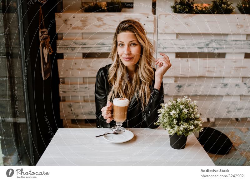 Frau, die Kaffee aus einem Glas trinkt lecker genießen unordentlich schäumen heiter Erwachsener süß Café geschmackvoll Kantine blond stylisch Glück Vergnügen