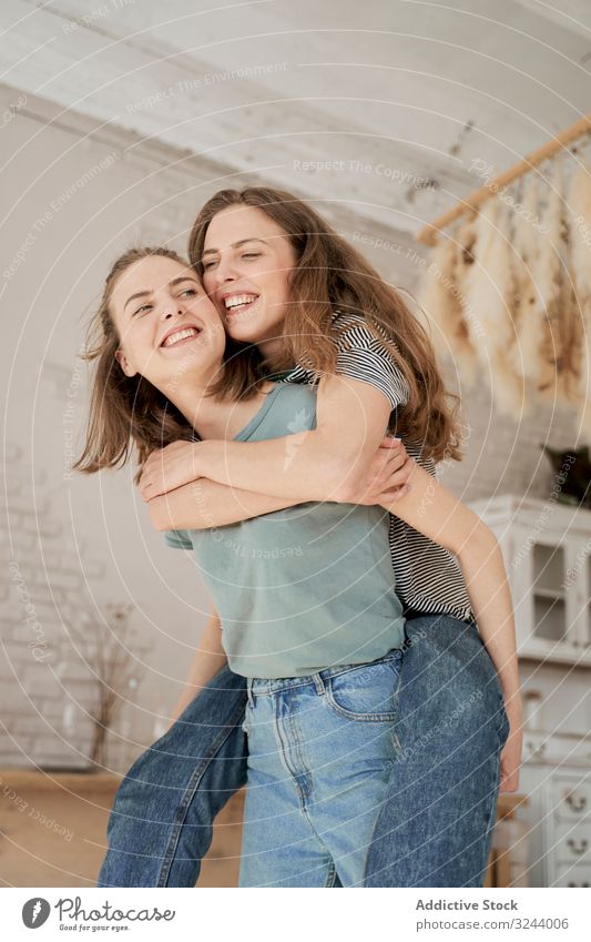 Lachende Freundinnen sitzen auf der Waschmaschine im Haus heimwärts Spaß Paar heimisch Frauen Freizeit Umzug Liebe räkeln Barfuß Zusammensein Komfort Hausarbeit