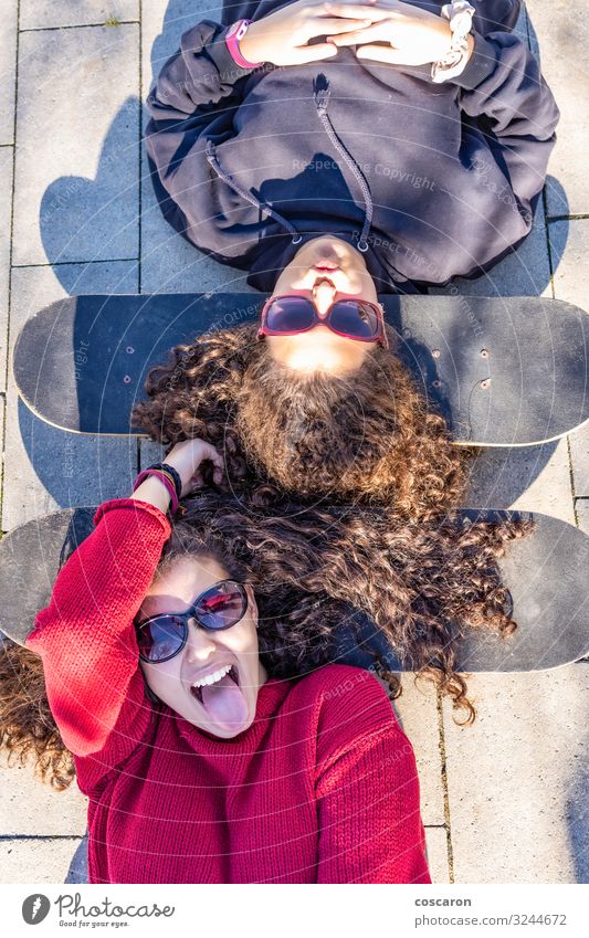 Zwei junge Skater, die mit den Köpfen auf ihren Boards ruhen. Lifestyle Stil Freude Glück Freizeit & Hobby Brettspiel Sommer Sport Mensch feminin Junge Frau