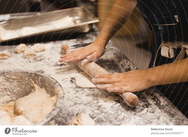 Bäcker rollt Teig in der Küche aus Teigwaren rollen Bäckerei Brot Lebensmittel Gebäck Mehl Mahlzeit Nudelholz Tisch Weizen Küchenchef Restaurant Vorbereitung