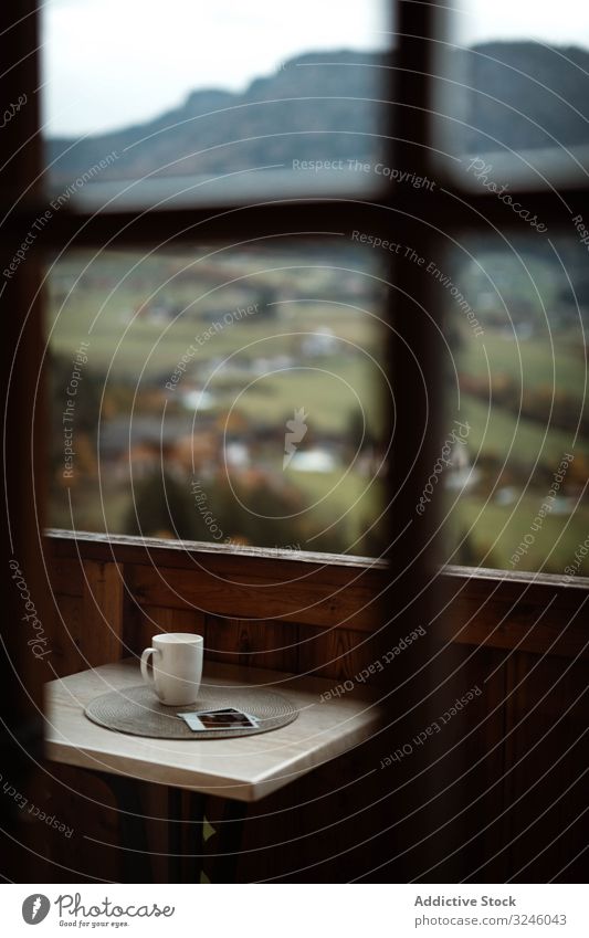 Kleiner Tisch mit einer Tasse Kaffee und Fotos auf der Terrasse an einem bewölkten Morgen Natur Berge u. Gebirge Tee Getränk Gedächtnis ländlich modern