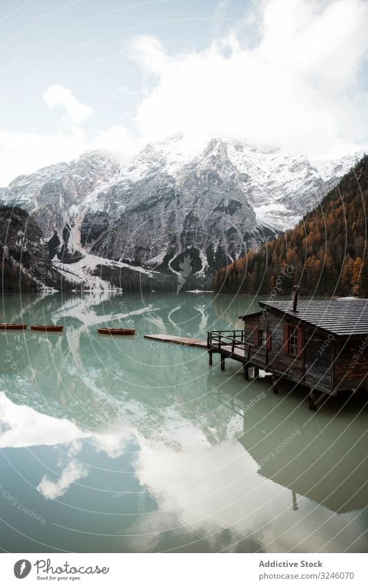 Haus auf Stelzen am See in der Nähe der Berge Berge u. Gebirge Boot hölzern Reflexion & Spiegelung Natur reisen Wasser Landschaft Himmel Ansicht Tourismus