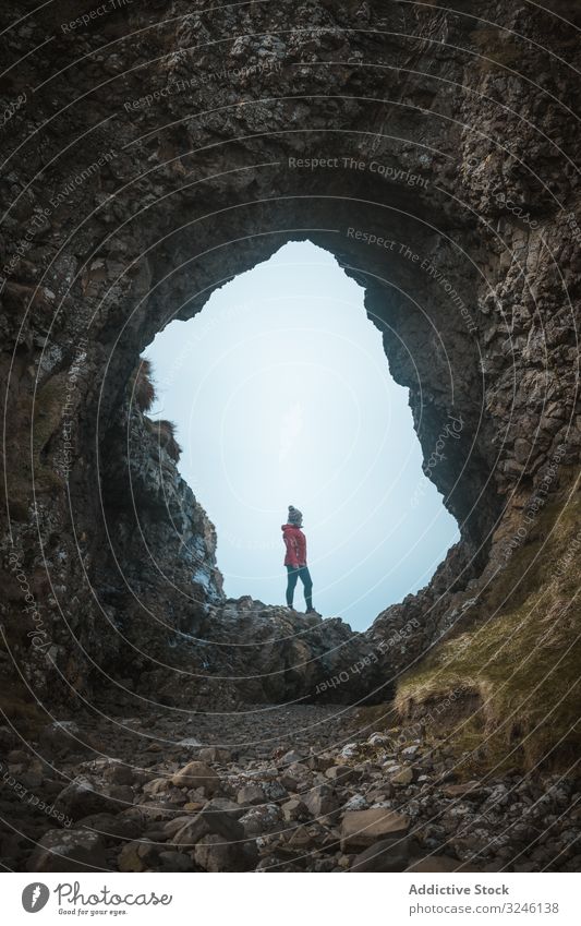 Frau steht in Felshöhle Felsen Höhle Klippe Saum Hafen Stein Natur Berge u. Gebirge erkunden Tourist Landschaft Wand Bodenerhebung Höhe antik Hügel Felsspitze