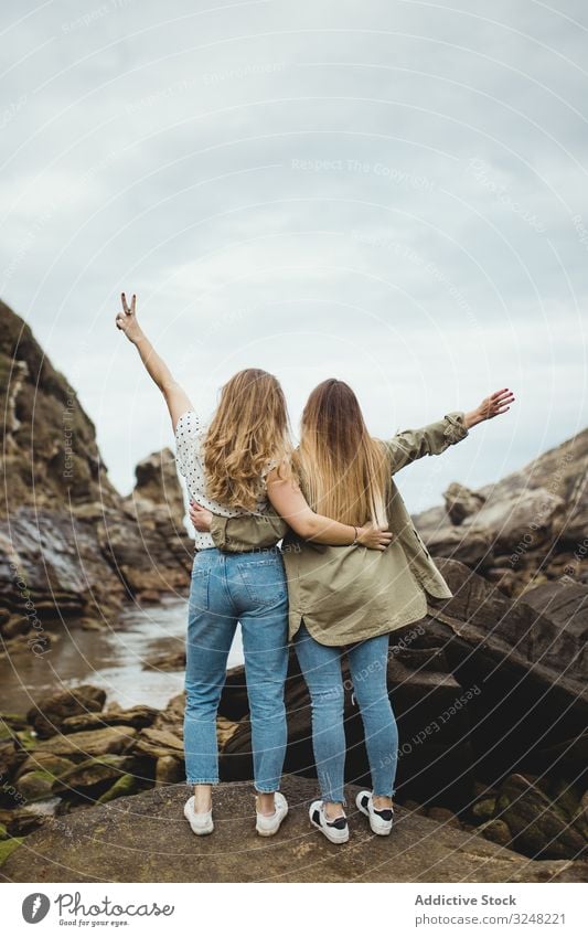 Junge Schwestern stehen am Frühlingstag auf Stein Frauen Umarmen Natur Hügel Berge u. Gebirge Landschaft Zusammensein Freunde Liebe Umarmung abstützen