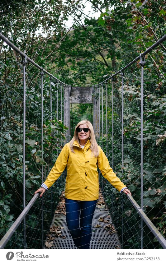 Fröhliche Touristin steht im Sommer auf Hängebrücke Frau Steg Wald heiter Urlaub Suspension Sommerzeit Tourismus erhängen reisen Reise Natur Abenteuer Park