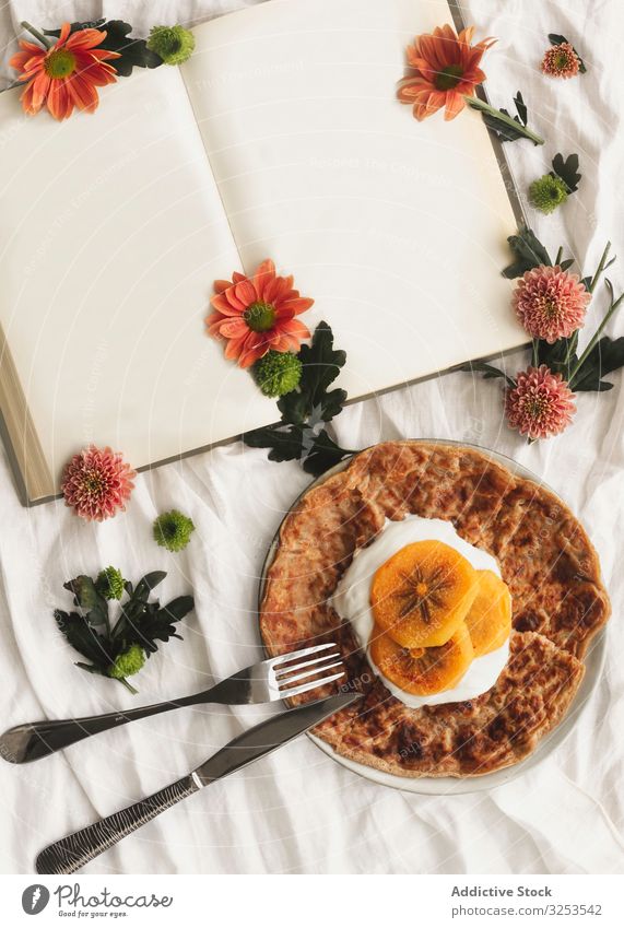 Crêpes mit Sahne und Kakipflaume Frucht Persimone Lebensmittel rötlich Dessert geschmackvoll Gabel Portion Messer Buch Blumen Scheibe lecker Teller Stoff