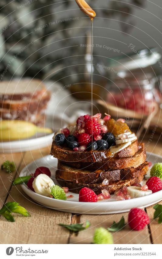 Honig über gebratene Toasts mit Früchten gießen Zuprosten Frucht Liebling eingießen Stapel verschütten Tisch Minze Frühstück Morgen Lebensmittel Dessert Snack