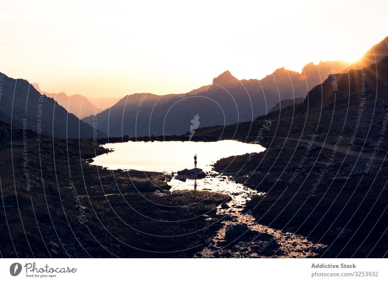 Am Ufer stehende Person, die sich im Wasser spiegelt Silhouette See Berge u. Gebirge Reflexion & Spiegelung malerisch ruhig Seeküste Stein Sonnenuntergang