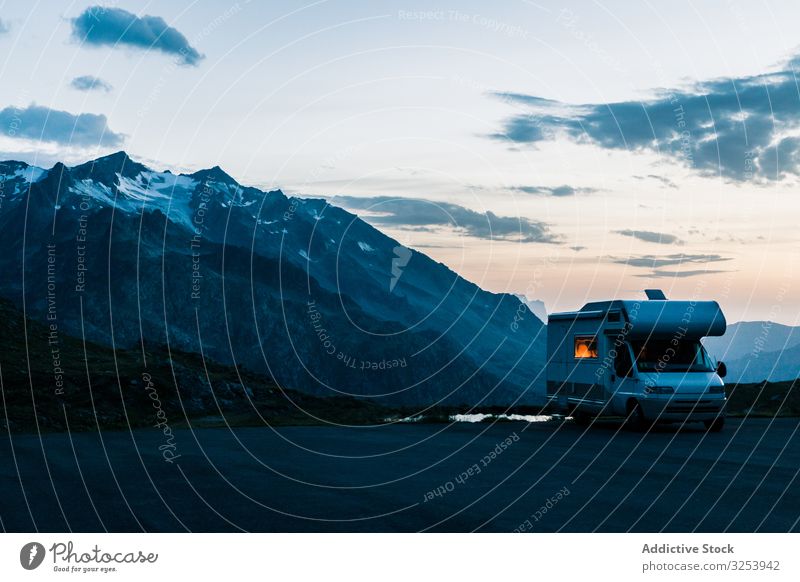 Wohnmobil auf der Straße entlang verschneiter Berge Berge u. Gebirge Urlaub Laufwerk Dämmerung Fahrzeug Ausflugsziel Natur Abenteuer Feiertag Autoreise Freiheit