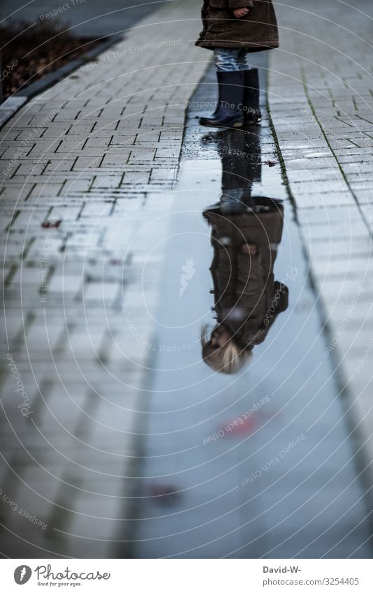 Kind spiegelt sich in einer Pfütze Mädchen Spiegelung Spiegelung im Wasser nachdenklich Reflexion & Spiegelung Herbst düster draußen grau