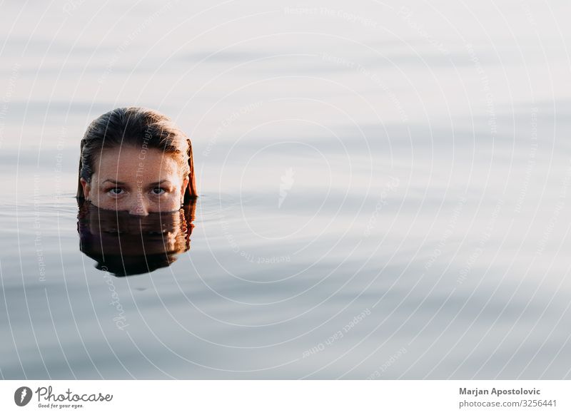 Junge Frau im Meer im Licht des Sonnenuntergangs Lifestyle Freude Ferien & Urlaub & Reisen Tourismus Sommer Sommerurlaub Mensch feminin Jugendliche Erwachsene