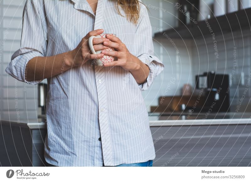 junge Frau, die zu Hause Kaffee trinkt Frühstück Getränk Tee Lifestyle Glück schön Gesicht Erholung Freizeit & Hobby Tisch Küche Mensch Erwachsene Wärme