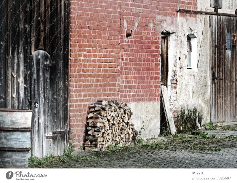 Holz vor der Hütte Häusliches Leben Wohnung Dorf Menschenleer alt Bauernhof Brennholz Holzstapel Scheune Scheunentor Backsteinwand Hof Farbfoto Außenaufnahme