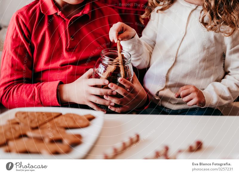 schönes Geschwisterpaar zu Hause bei einem leckeren Snack. Weihnachts-Konzept Plätzchen Süßwaren Hermano Schwester Weihnachten & Advent heimwärts blond