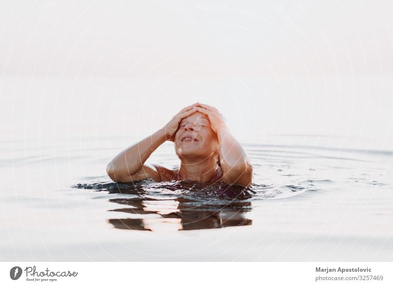 Junge Frau im Meer im Sonnenuntergang Lifestyle Freude Wellness Leben harmonisch Erholung Schwimmen & Baden Ferien & Urlaub & Reisen Tourismus Freiheit Sommer