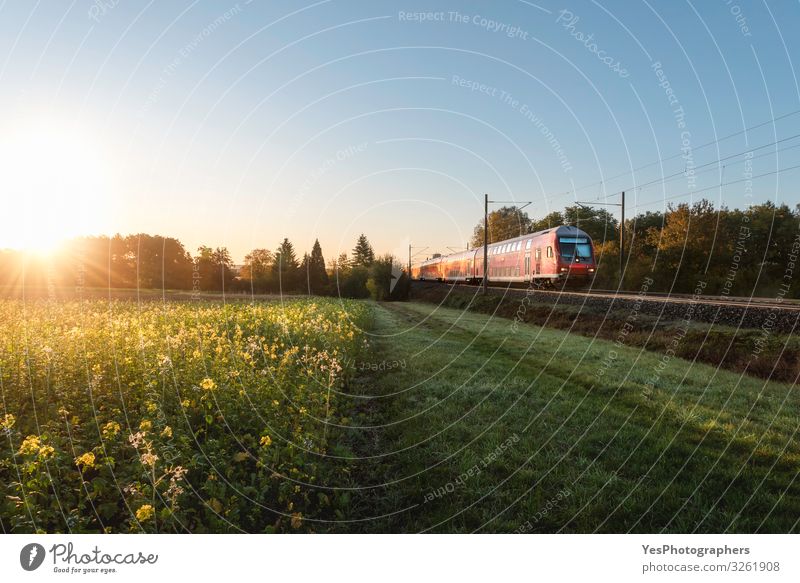 Roter Zug und Frühlingslandschaft bei Sonnenaufgang. Kontext der Frühjahrsreisen Ferien & Urlaub & Reisen Umwelt Natur Landschaft Sonnenuntergang Verkehr