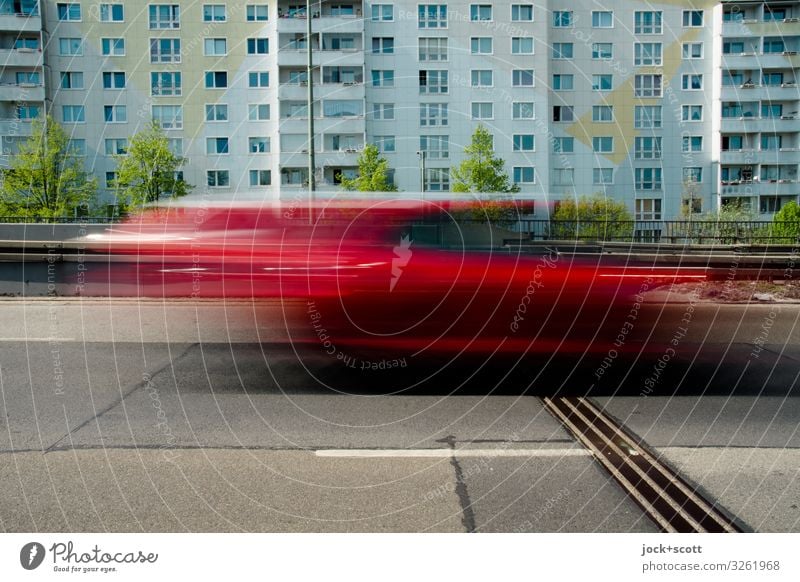 Tempo auf der Stadtautobahn Plattenbau Fassade Verkehrswege PKW fahren Geschwindigkeit trist Stimmung Mobilität Fahrbahn abstrakt Sonnenlicht Langzeitbelichtung