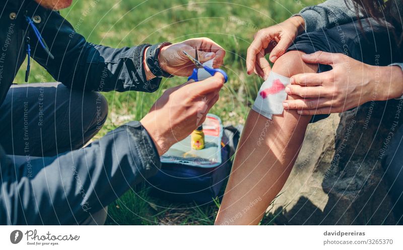 Mann heilt beim Trekking verletztes Knie einer Frau Lifestyle Berge u. Gebirge wandern Schere Mensch Erwachsene Paar Natur Herbst Wald sitzen authentisch Wunde