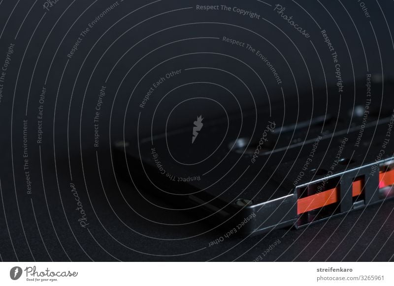 Alte schwarze Musikkassette auf schwarzem Untergrund, mit rotem Magnetband Tanzen Musik hören Tonband Medien alt dunkel retro Fortschritt Freizeit & Hobby