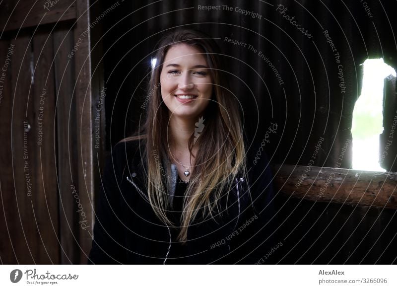 Portrait einer jungen lächelnden Frau vor einem Schuppen Stil Freude schön Leben Wohlgefühl Scheunentor Junge Frau Jugendliche 18-30 Jahre Erwachsene Landschaft