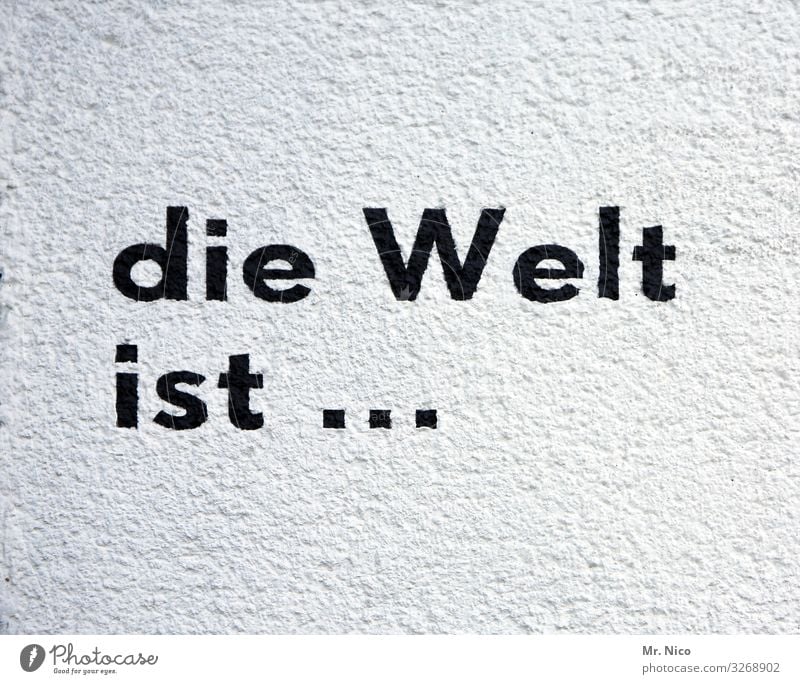 die Welt ist ... Schriftzeichen schwarz weiß Sprichwort Text Erde Putzfassade Redewendung Scheibe rund Dorf Buchstaben Aufschrift Parole Graffiti