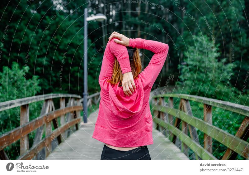 Nicht erkennbare Sportlerin, die im Freien die Arme streckt. Lifestyle Wellness Mensch Frau Erwachsene Park brünett Fitness sportlich dünn rosa unkenntlich