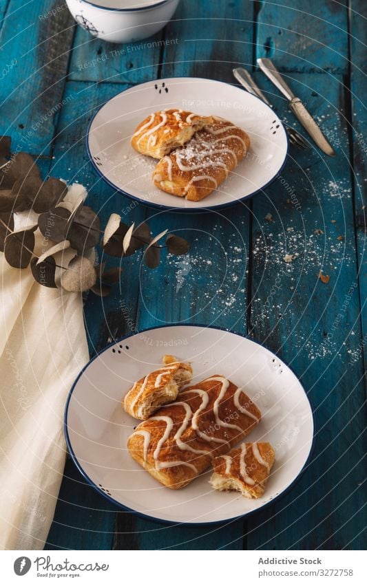 Hausgemachte schmackhafte süße Brötchen auf Tellern selbstgemacht süßes Brötchen frisch lecker Tisch Zuckerguß rustikal geschmackvoll gebacken Koch hungrig