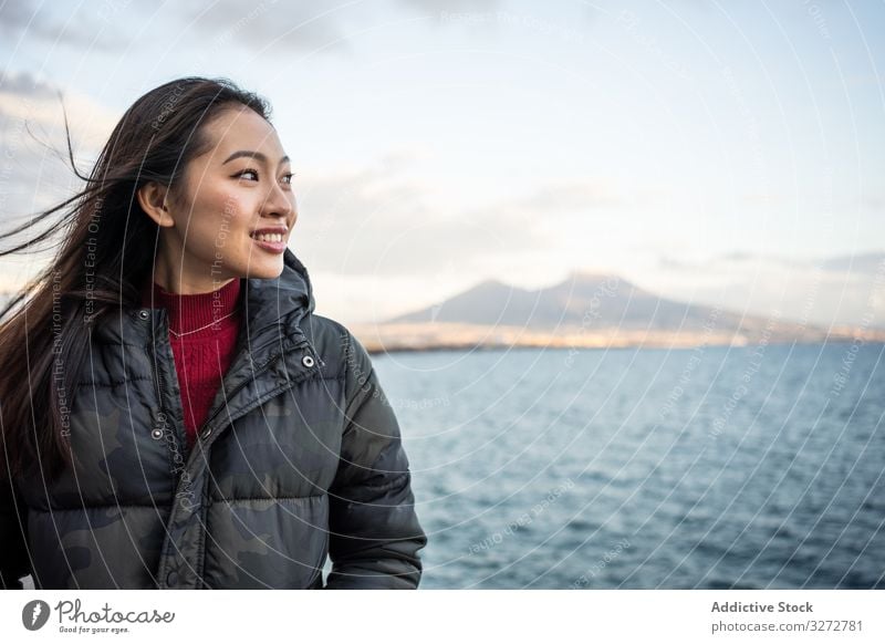 Frau im Urlaub in warmer Kleidung an der Meeresküste Meeresufer Cloud Himmel Lächeln genießen Lachen Freude reisen Tourismus sich[Akk] entspannen Wasser schön