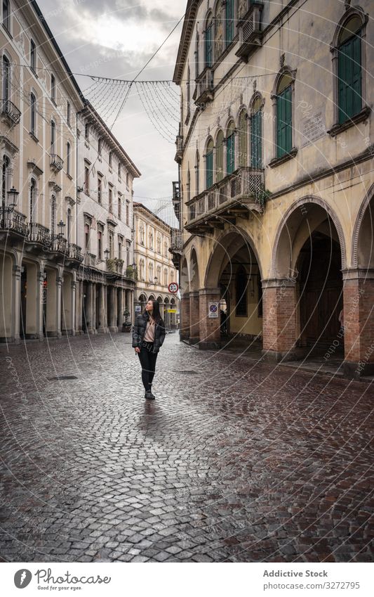 Neugierige Touristin schlendert bei bedecktem Himmel durch die Altstadt Tourismus laufen Großstadt Straße alt antik gealtert neugierig erkunden Architektur