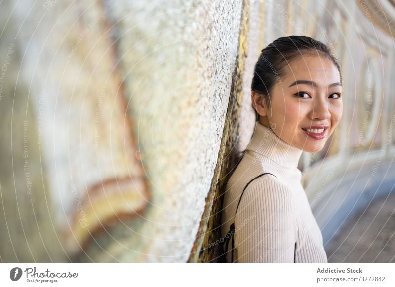 Zufriedene Asiatin ruht sich aus und besichtigt den Tempel Tourismus Sightseeing reisen Frau Lehnen Wand Fresken historisch alt antik asiatisch Heiliger Peter