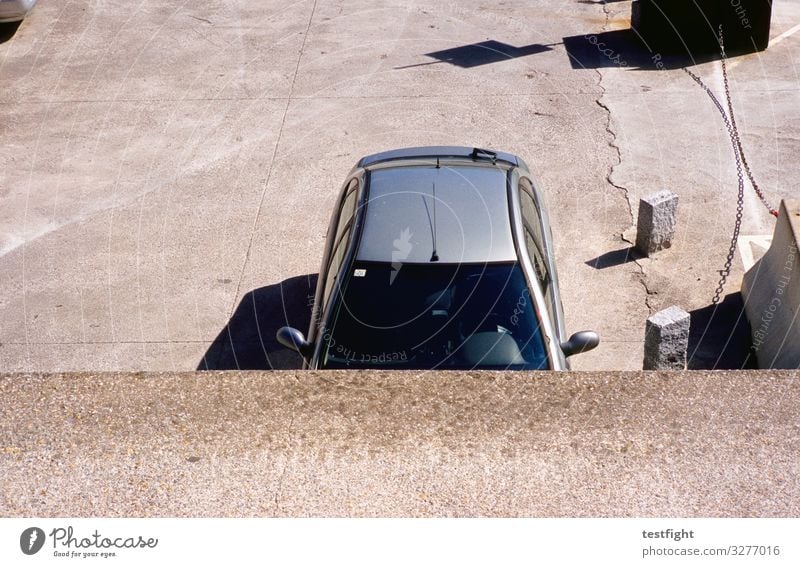 parkendes Auto Stadtrand Verkehr Straße Fahrzeug PKW beobachten Beton Metall Dach Schatten Farbfoto Außenaufnahme Textfreiraum unten Licht Kontrast