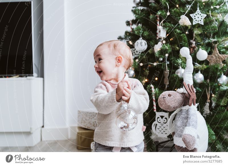 fröhliches kleines Mädchen beim Schmücken des Weihnachtsbaums Glück niedlich Baby ein Jahr dekorierend Weihnachten & Advent Baum Freude Familie & Verwandtschaft