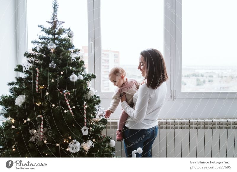 glückliche Mutter und Mädchen, die den Weihnachtsbaum schmücken Mutterschaft Glück niedlich Baby ein Jahr dekorierend Weihnachten & Advent Baum Freude