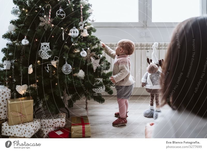 glückliche Mutter und Mädchen, die den Weihnachtsbaum schmücken Mutterschaft Glück niedlich Baby ein Jahr dekorierend Weihnachten & Advent Baum Freude