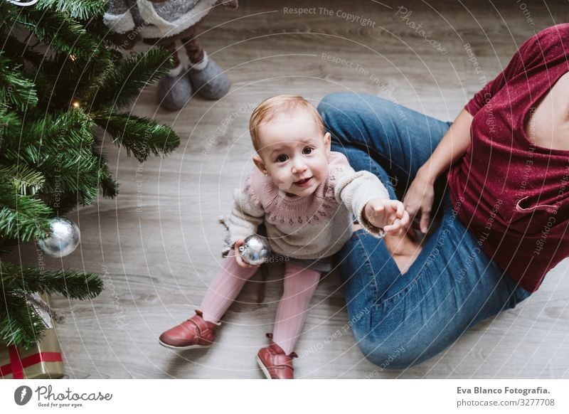 glückliche Mutter und Mädchen, die den Weihnachtsbaum schmücken Mutterschaft Glück niedlich Baby ein Jahr dekorierend Weihnachten & Advent Baum Freude