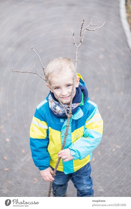 Junge mit einem Ast als Geweih Kleinkind ast draußen drei Jahre freude fröhlich geweih jacke junge kindheit kopf lachen lächeln männlich spiel spielen spielt