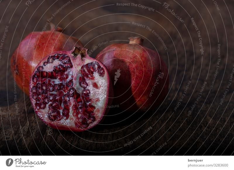 drei Granatäpfel Frucht Dessert Vegetarische Ernährung Saft exotisch Holz frisch hell lecker saftig rot weiß Granatapfel rustikal offen Hälfte Teilung