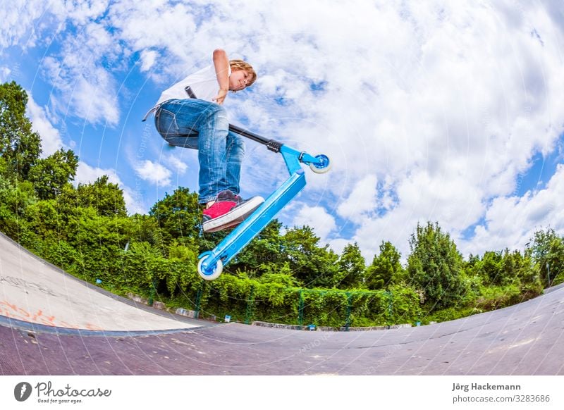 Junge mit Roller geht in die Luft Lifestyle Freude Glück Freizeit & Hobby Sport Kind Mensch Mann Erwachsene Kindheit Himmel Wetter Park Bewegung Fitness