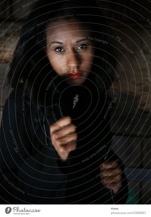 Lea feminin Frau Erwachsene 1 Mensch Jacke schwarzhaarig langhaarig beobachten Denken festhalten Blick warten dunkel Sicherheit Schutz Wachsamkeit Ausdauer