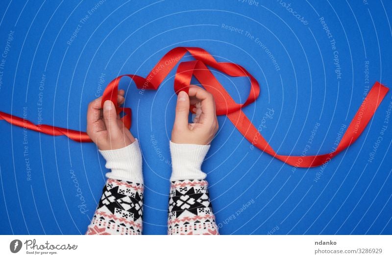 Frauenhände halten ein rotes Satinband Design Dekoration & Verzierung Feste & Feiern Weihnachten & Advent Geburtstag Werkzeug Hand Stoff Locken Schnur blau weiß