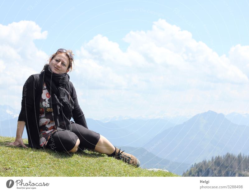 eine Frau sitzt bei schönem Wetter auf einem Berg, im Hintergrund sieht man die Alpen Mensch feminin Erwachsene 1 45-60 Jahre Umwelt Natur Landschaft Pflanze