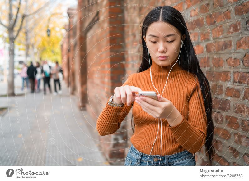 Asiatische Frau, die ihr Mobiltelefon benutzt. Lifestyle Freude schön Erholung Dekoration & Verzierung Telefon PDA Technik & Technologie Internet Mensch